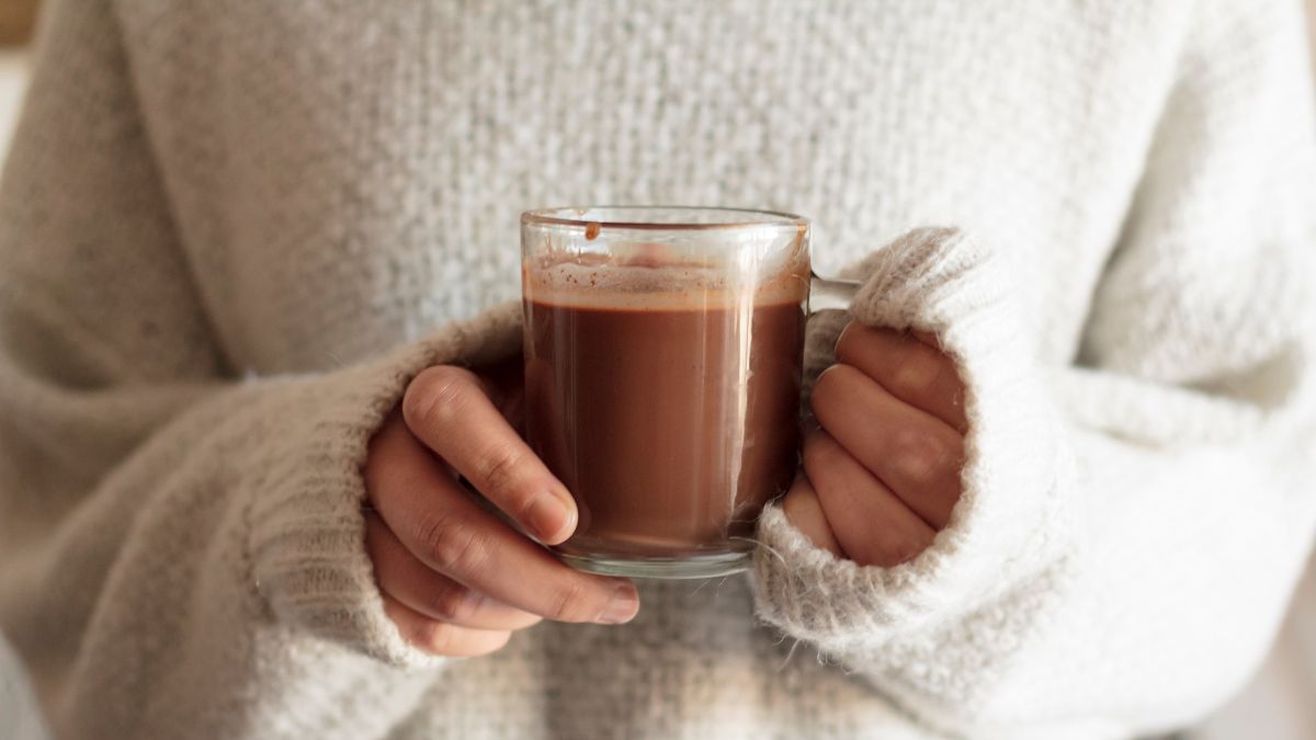 Mulher segurando uma xícara de chocolate quente