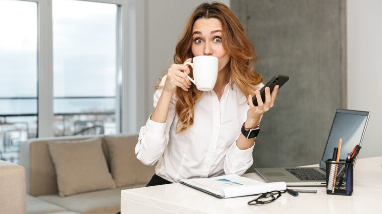 mulher assustada tomando uma xícara de café no escritório