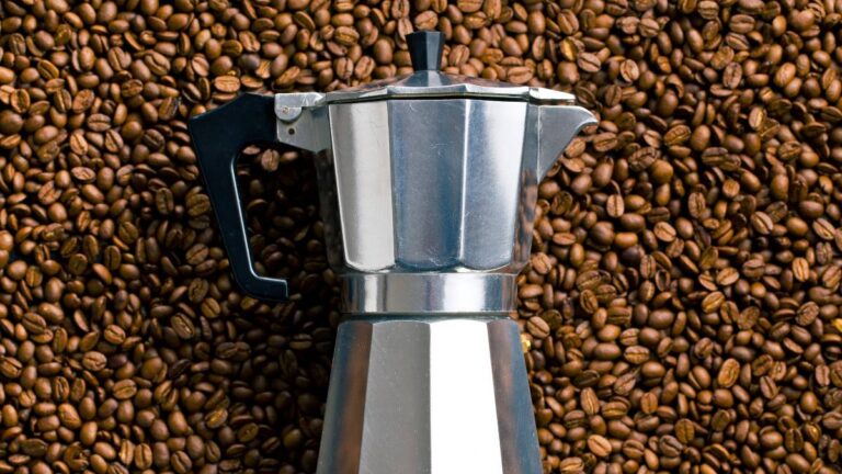 cafeteira italiana em cima de grãos de café