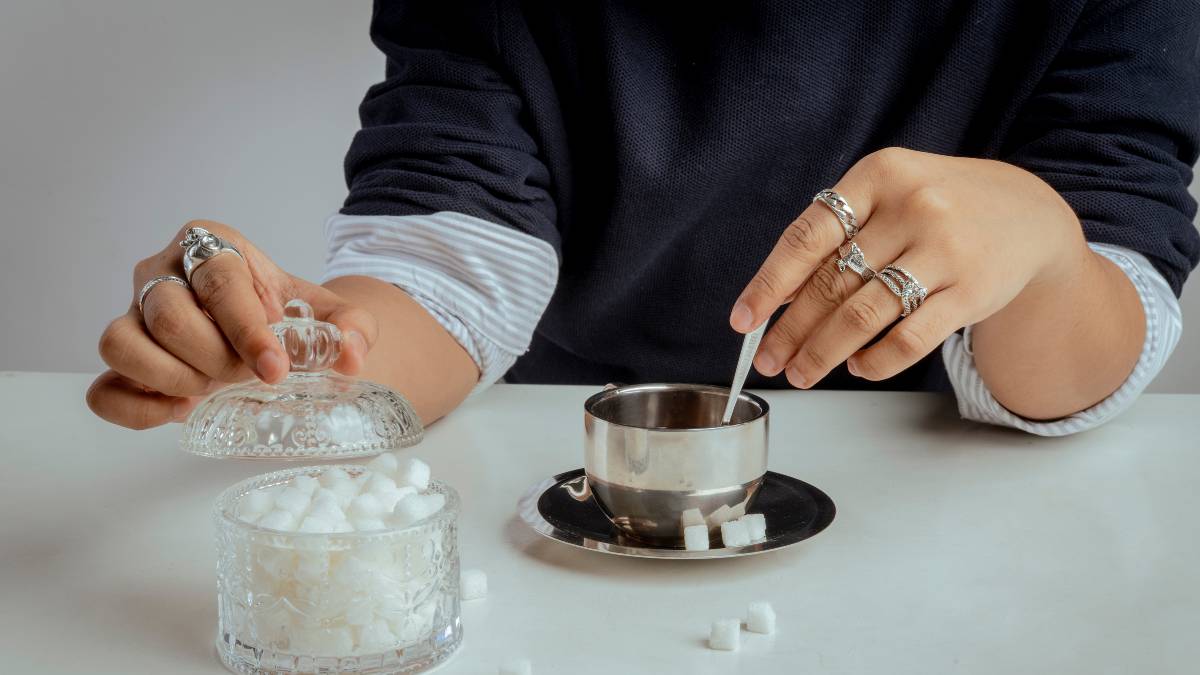 Pessoa adoçando café com colher